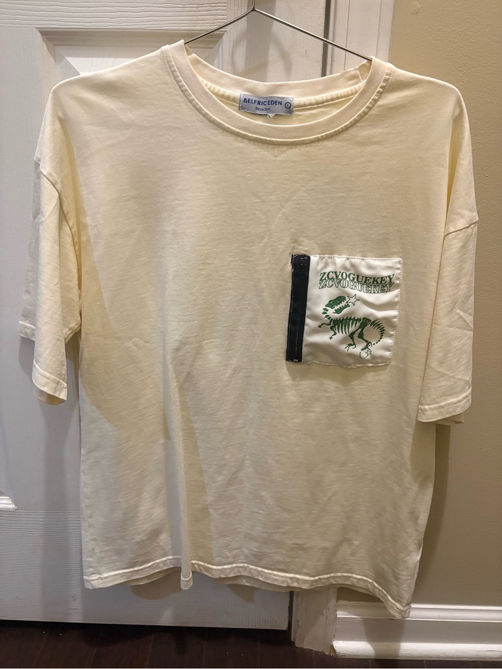 Aelfric Eden Cream Tee with Green Dinosaur Pocket & back Large